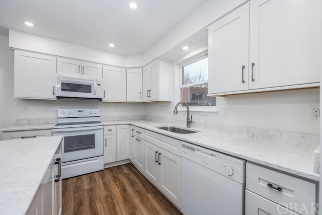 kitchen with white appliances, dark wood-style floors, white cabinetry, and a sink