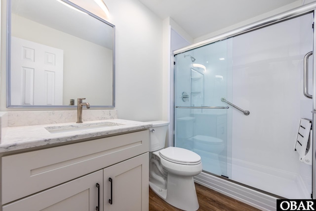 full bathroom featuring toilet, a shower stall, wood finished floors, and vanity