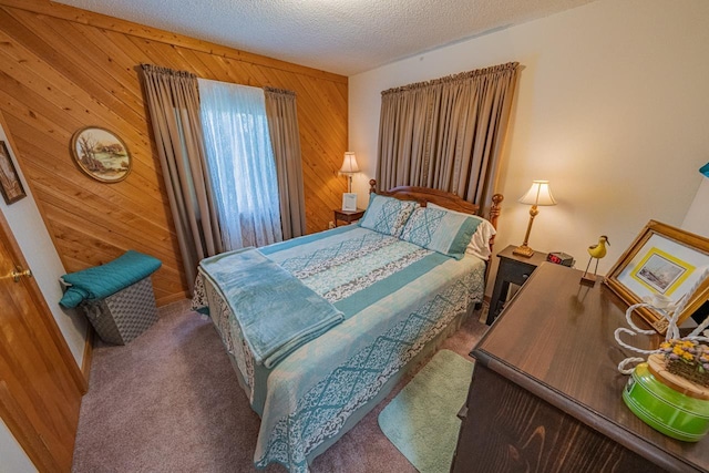 carpeted bedroom with wooden walls and a textured ceiling