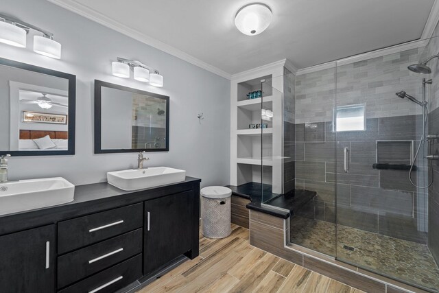 bathroom featuring ornamental molding, double vanity, a sink, and wood finished floors