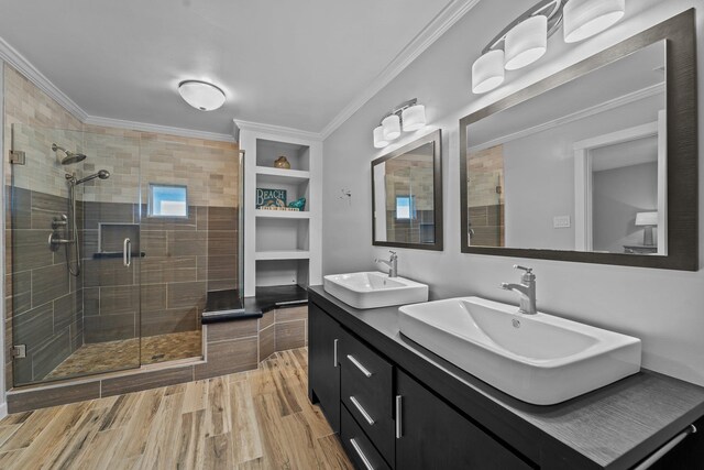 bathroom with ornamental molding, a stall shower, and a sink