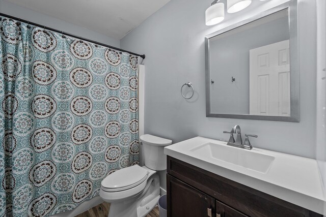 full bathroom with vanity, toilet, and wood finished floors