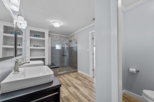 full bathroom featuring ornamental molding, a sink, and wood finished floors