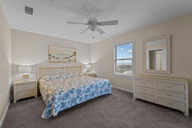 bedroom featuring a ceiling fan, visible vents, dark carpet, and baseboards