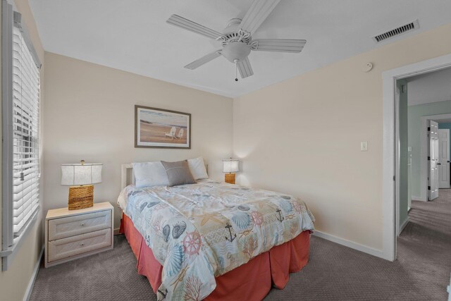 bedroom with ceiling fan, baseboards, visible vents, and dark carpet