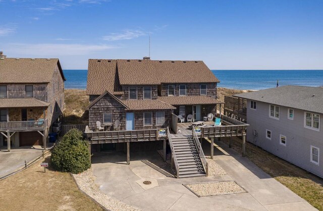 exterior space featuring stairway and a deck with water view