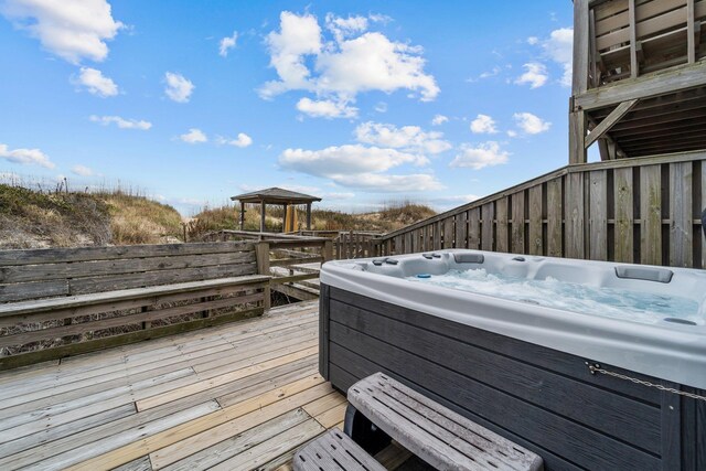 wooden terrace with a hot tub and a gazebo