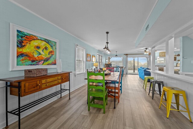 dining space with ceiling fan with notable chandelier, light wood-type flooring, and visible vents