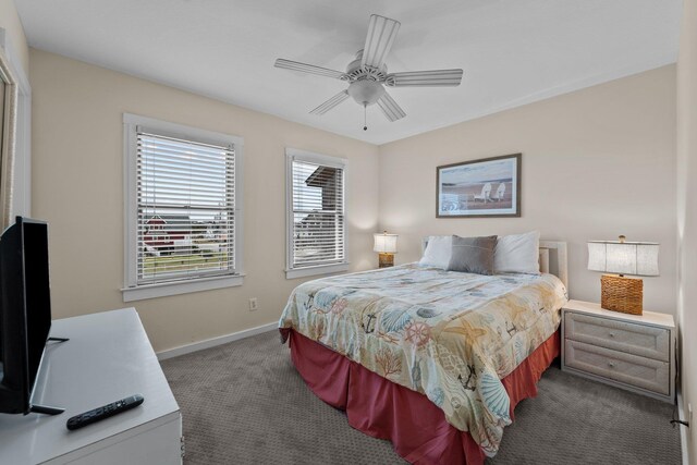 bedroom with dark colored carpet, ceiling fan, and baseboards