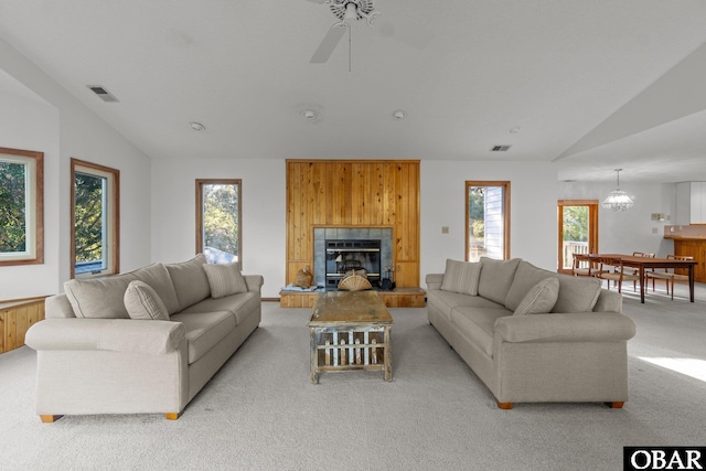 living room featuring light colored carpet, visible vents, vaulted ceiling, and a fireplace