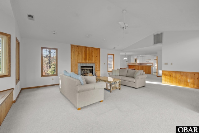 living area with visible vents, a fireplace, and light carpet