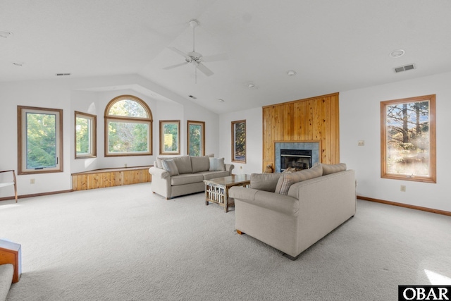 living area with light colored carpet, vaulted ceiling, visible vents, and a fireplace