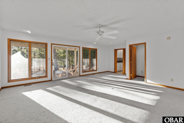 spare room with visible vents, baseboards, a textured ceiling, and light colored carpet