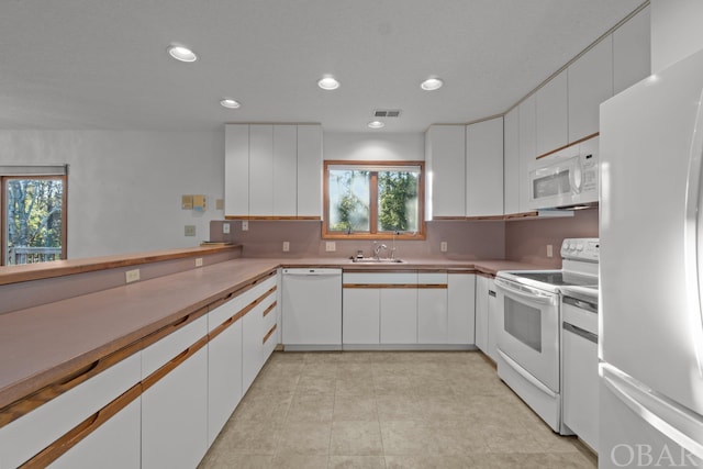 kitchen featuring white appliances and white cabinetry