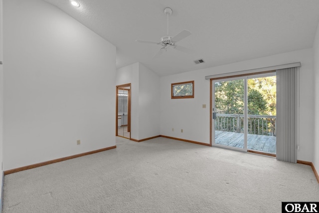 carpeted spare room featuring visible vents, vaulted ceiling, baseboards, and ceiling fan