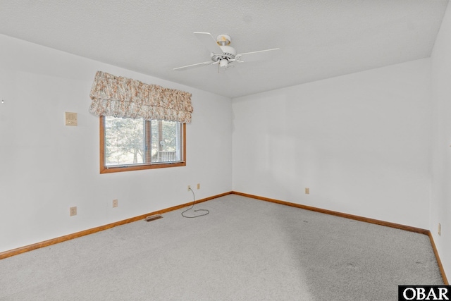 unfurnished room featuring ceiling fan, a textured ceiling, carpet floors, visible vents, and baseboards