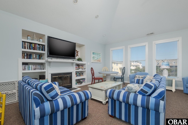 carpeted living area with a glass covered fireplace, built in features, baseboards, and visible vents