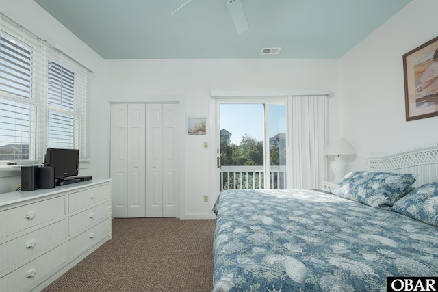 bedroom featuring access to exterior, multiple windows, visible vents, and dark colored carpet