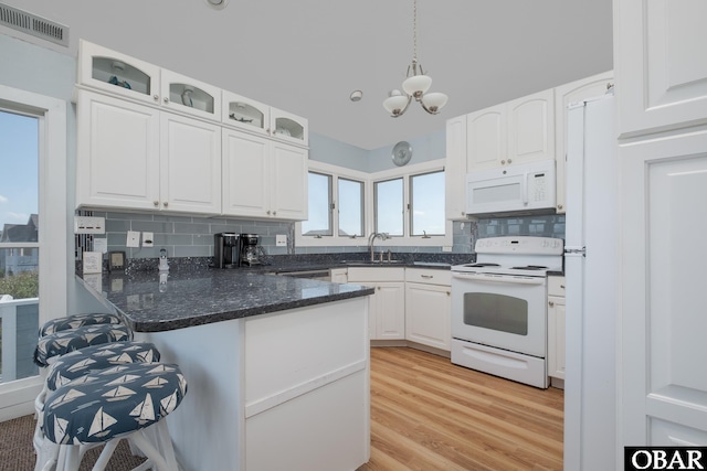 kitchen with visible vents, white appliances, glass insert cabinets, and white cabinets