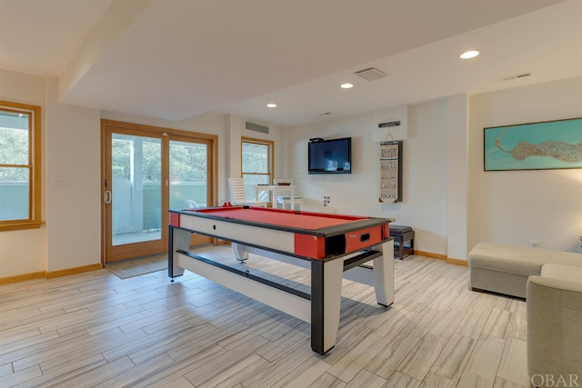 rec room with light wood-style floors, a wealth of natural light, and visible vents