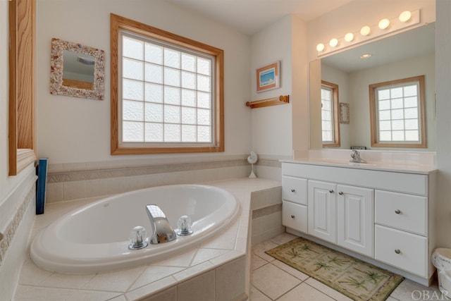 bathroom featuring tile patterned flooring, a garden tub, and vanity