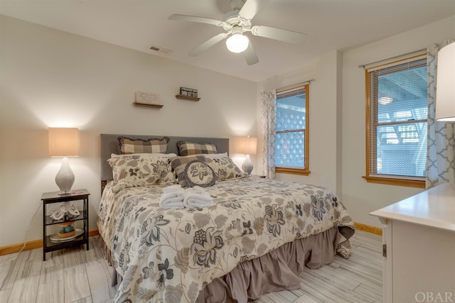 bedroom featuring a ceiling fan, visible vents, and baseboards