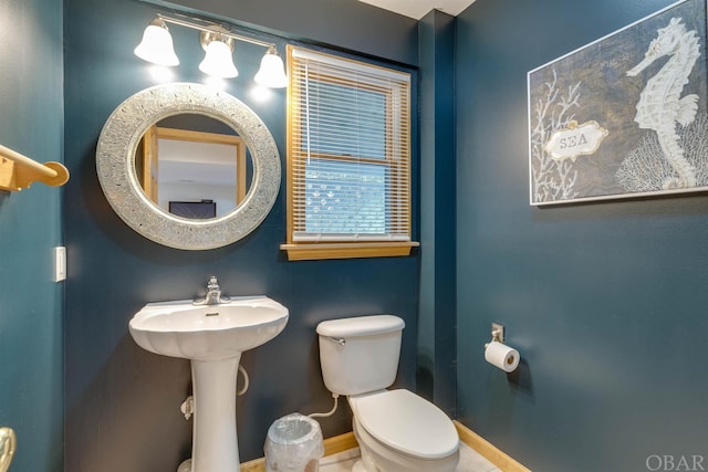 bathroom with toilet and baseboards