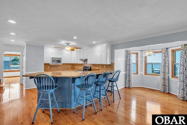 kitchen with dark stone counters, stainless steel appliances, recessed lighting, and white cabinetry