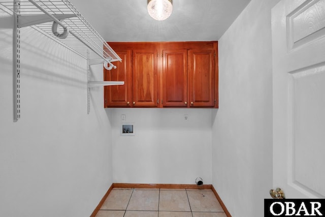 clothes washing area featuring cabinet space, light tile patterned flooring, washer hookup, and baseboards