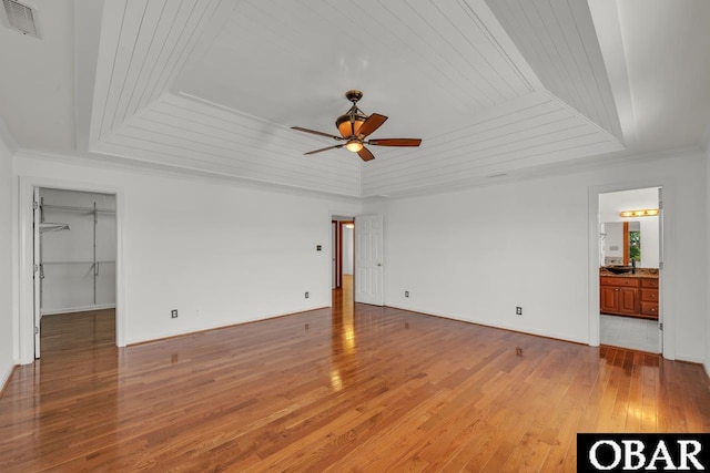 interior space with visible vents, ceiling fan, light wood-type flooring, wood ceiling, and a tray ceiling