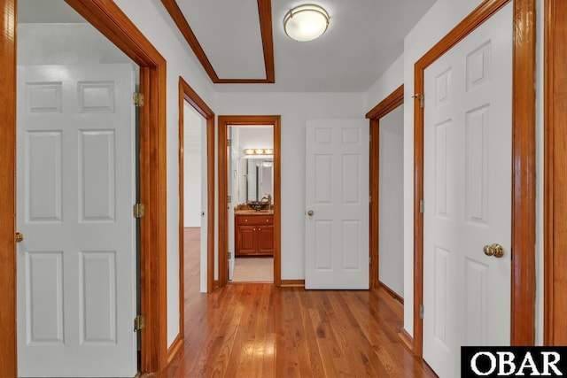hall featuring light wood-style floors and baseboards