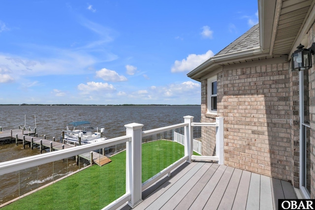 wooden terrace with a yard, a water view, and a boat dock