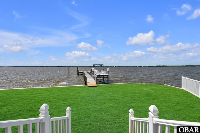 view of dock with a lawn, boat lift, and a water view