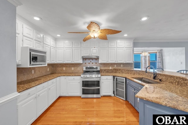 kitchen featuring a sink, white cabinetry, a peninsula, and stainless steel appliances