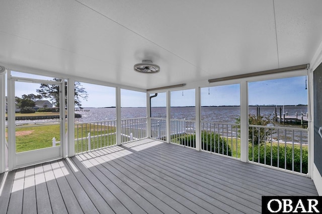 unfurnished sunroom featuring a water view