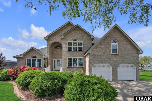 traditional home with an attached garage, brick siding, and concrete driveway