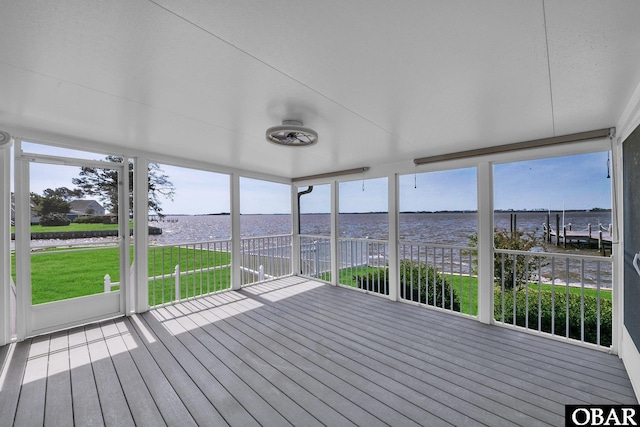 unfurnished sunroom featuring a water view