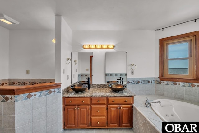 bathroom with double vanity, a sink, and a whirlpool tub
