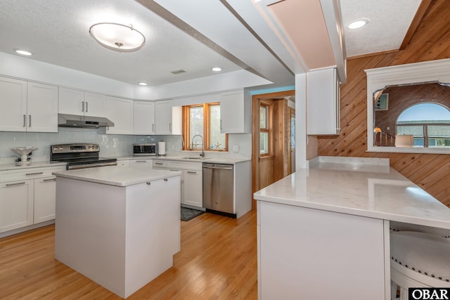 50011 Kings Point Dr Lot 335, Frisco, NC 27936 - kitchen featuring stainless steel appliances, a peninsula, a sink, white cabinetry, and under cabinet range hood