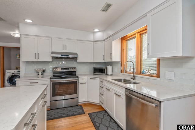 50011 Kings Point Dr Lot 335, Frisco, NC 27936 - kitchen with stainless steel appliances, a sink, visible vents, under cabinet range hood, and washer / dryer
