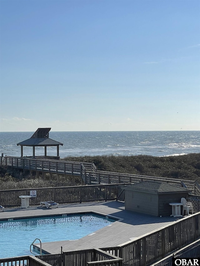 pool with a deck with water view and a gazebo