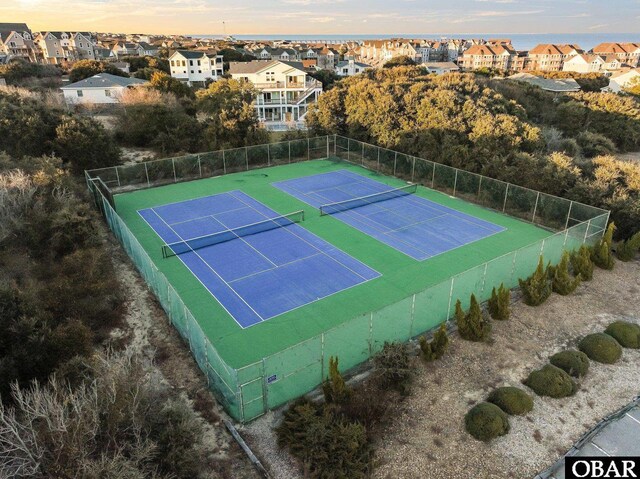 view of sport court with fence and a residential view