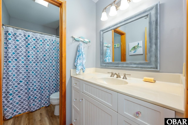 bathroom with a shower with shower curtain, vanity, toilet, and wood finished floors