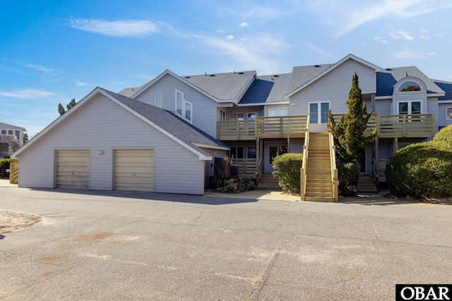 view of property with a garage, an outdoor structure, and stairway