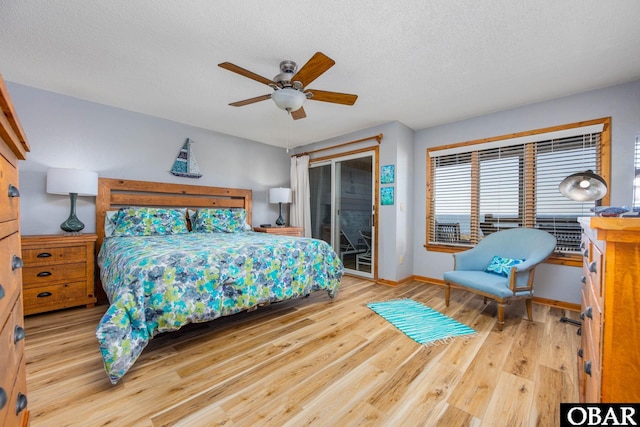 bedroom with access to outside, a textured ceiling, and wood finished floors