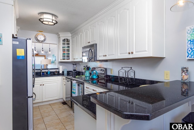 kitchen with appliances with stainless steel finishes, white cabinets, a sink, a peninsula, and a kitchen breakfast bar