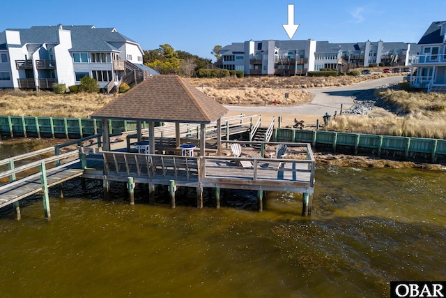 dock area featuring a water view, a residential view, and fence