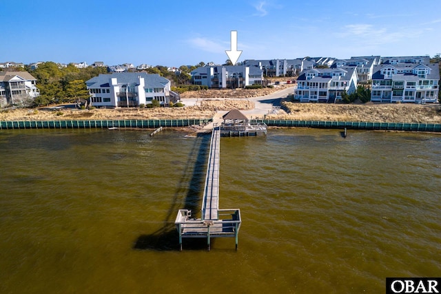 view of dock with a residential view and a water view