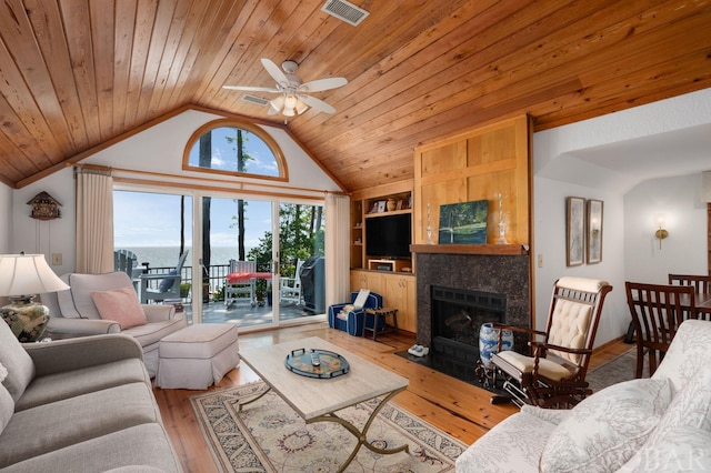 living area with built in shelves, wood ceiling, visible vents, and a tiled fireplace