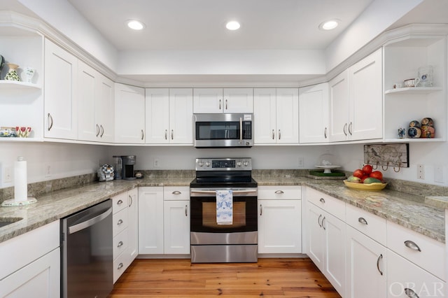 kitchen with stainless steel appliances, light wood-type flooring, open shelves, and white cabinets